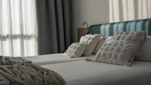 a bedroom with two beds with white blankets and pillows at Hotel Princesa De Eboli in Pinto