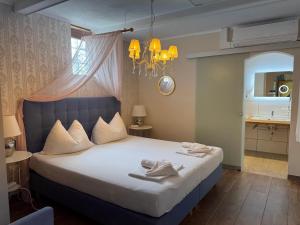 a bedroom with a large bed and a chandelier at Pension Amelie in Mörbisch am See