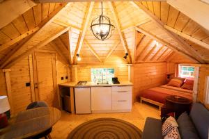 a room with a kitchen and a bed in a cabin at Aux Étangs de Jourgnac - Kota in Jourgnac