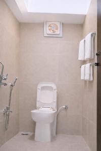 a bathroom with a toilet and a shower with towels at Ekaay The Boutique Hotel in Kumārkara