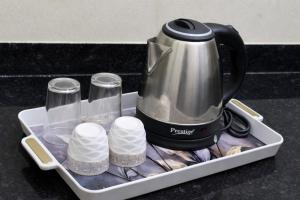 a tea kettle and cups in a tray on a counter at Ekaay The Boutique Hotel in Kumārkara