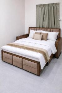 a bed with a wooden frame and pillows on it at Ekaay The Boutique Hotel in Kumārkara