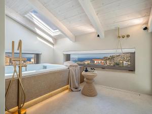 a bathroom with a large tub and a window at Villa Villagio Rosso in Kókkinon Khoríon