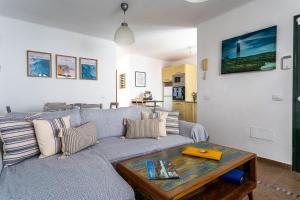 a living room with a couch and a table at Casa Lili - Shared Pool - Close to Seafront Promenade - Sea Views from upper terrace in Punta Mujeres