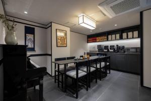 a dining room with a table and chairs and a kitchen at Hotel Jak Insadong by Anook in Seoul