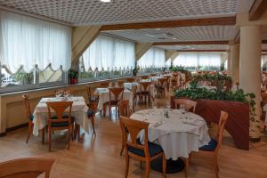 a restaurant with tables and chairs and windows at Aparthotel Holiday in Bibione +120 photos