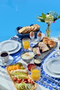 a table with breakfast foods on a blue and white table cloth at Yianna Hotel in Skala