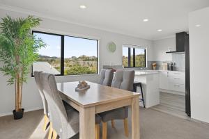 a kitchen and dining room with a table and chairs at Welcome Bay Stay in Tauranga
