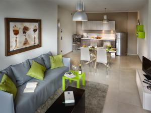 a living room with a blue couch and a kitchen at Rivetto Suites in Alba