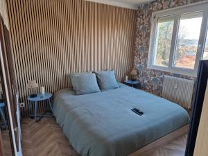 a bedroom with a large bed with two tables at La détente in Lons-le-Saunier