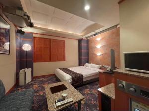a hotel room with two beds and a tv at HOTEL Bew Rose Mary in Kai