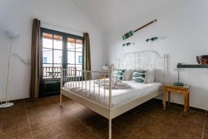 a white bed in a room with a window at Casa Lili - Shared Pool - Close to Seafront Promenade - Sea Views from upper terrace in Punta Mujeres +46 photos