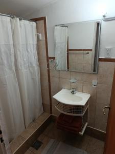 a bathroom with a sink and a shower with a mirror at EL LOTE DE VERO in Las Compuertas +18 photos
