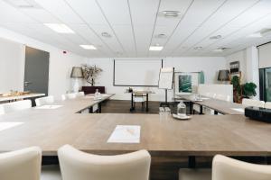 a meeting room with tables and chairs and a whiteboard at Resort Land & Zee in Scharendijke