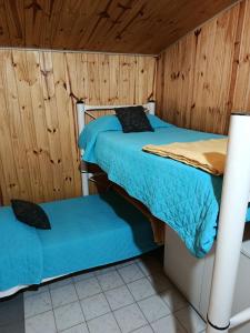 two beds in a room with wooden walls at EL LOTE DE VERO in Las Compuertas