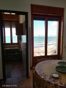 a dining room with a table and a view of the beach at AFRODITE in Porto Cesareo