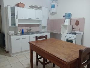 a kitchen with white cabinets and a wooden table at En Santa Rosa in Santa Rosa