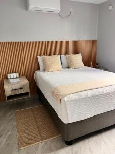 a bedroom with a large bed with a wooden headboard at Marble Crest Guest House in Maun