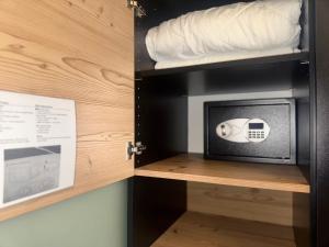 a cupboard with a microwave and a bed in it at Pension Amelie in Mörbisch am See