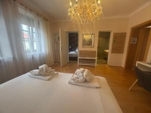 two towels on a table in a room with a chandelier at Pension Amelie in Mörbisch am See +191 photos
