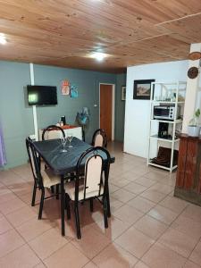 a dining room with a black table and chairs at EL LOTE DE VERO in Las Compuertas