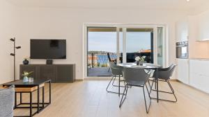 a kitchen and living room with a table and chairs at Luxury Apartment Nala with shared pool in Sevid
