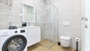 a bathroom with a washing machine and a glass shower at Luxury Apartment Nala with shared pool in Sevid +49 photos