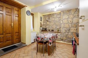 a kitchen with a table and a stone wall at The Stone House Historic Center in Grotte di Castro