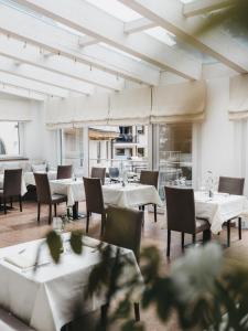 a dining room with white tables and chairs at VAYA Post Saalbach Landhaus in Saalbach-Hinterglemm