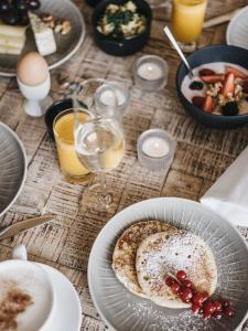 a table with a plate of food and glasses of wine at VAYA Post Saalbach Landhaus in Saalbach-Hinterglemm +5 photos