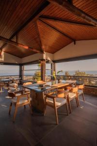 a restaurant with tables and chairs and a view of the ocean at Kaira Kazdaglari in Edremit