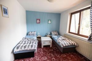 a bedroom with two beds and a table and a window at Apartmán Absolon Blansko in Blansko