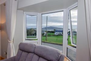 a living room with a couch and a large window at Sea View Heights in Rathmullan