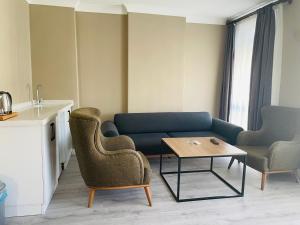 a living room with a couch and two chairs and a table at Centrum Hotel in Ankara