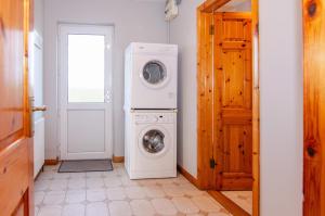 a laundry room with a washer and dryer next to a door at Sea View Heights in Rathmullan