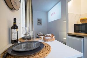 a table with a plate of food and a bottle of wine at Vidéoprojecteur - Tout à pied - Centre - Balcon in Montpellier