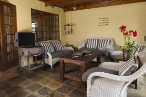 a living room with couches and a tv and a table at Elgin Farm Dullstroom in Dullstroom
