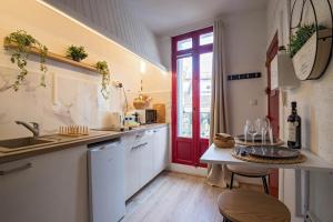 a kitchen with a sink and a red door at Vidéoprojecteur - Tout à pied - Centre - Balcon in Montpellier
