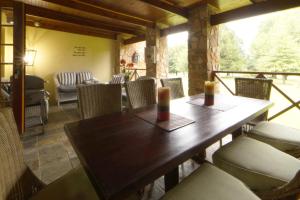 a dining room with a wooden table and chairs at Elgin Farm Dullstroom in Dullstroom