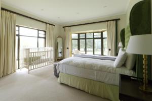 a bedroom with a large bed and a balcony at Elgin Farm Dullstroom in Dullstroom