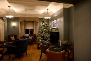 a living room with a christmas tree and chairs at Y Seren Hotel & Restaurant in Carmarthen