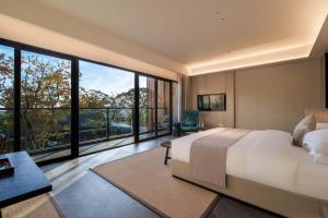 a bedroom with a large bed and large windows at cloud retreat·half an ocean hotel in Zhoushan