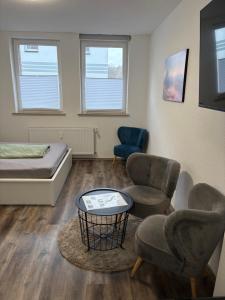a room with a bed and two chairs and a table at Gemütliche Suite im Erdgeschoss - WLAN in Hinsel