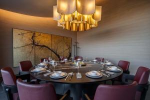 a dining room with a table and chairs and a chandelier at cloud retreat·half an ocean hotel in Zhoushan