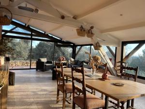 a living room with a wooden table and chairs at Mas des Côtes in Saint-Hippolyte-le-Graveyron
