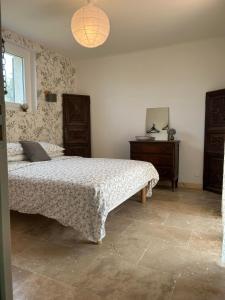 a bedroom with a bed and a dresser in it at Mas des Côtes in Saint-Hippolyte-le-Graveyron