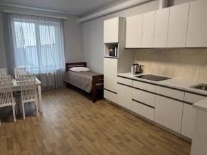 a kitchen with a table and a bed in a room at Надія in Khlibodarske