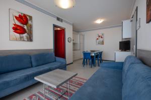 a living room with a blue couch and a table at Aparthotel Imperial in Bibione