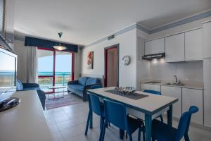 a kitchen and living room with a table and chairs at Aparthotel Imperial in Bibione