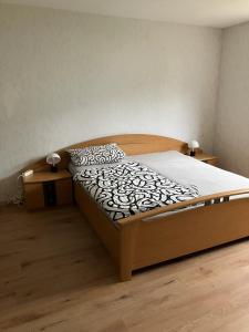 a wooden bed in a room with two night stands at Ferienwohnung Forstwiese in Großrosseln